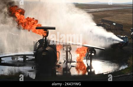 Feuerwehrmänner der 92. Civil Engineer Squadron führen Live-Feuertrainings auf der Fairchild Air Force Base, Washington, am 19. September 2022 durch. Die Übung lieferte Erfahrungen aus erster Hand mit Werkzeugen und Techniken, die zur Bekämpfung von Flugzeugbränden erforderlich sind. (USA Luftwaffe Foto von Airman Stassney Davis) Stockfoto