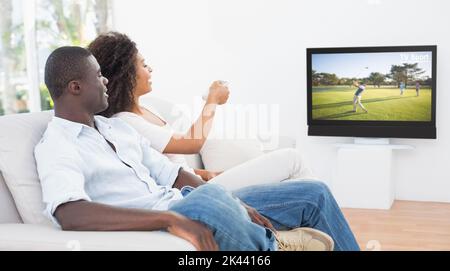Paar sitzt auf der Couch zusammen Fernsehen zu Hause im Wohnzimmer Stockfoto