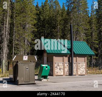 Ein tiersicherer Müllcontainer und ein öffentliches Badezimmer an einem Rastplatz in Field, British Columbia, Kanada an einem sonnigen Tag Stockfoto