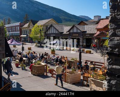 Personen, die im Außenbereich eines Restaurants auf der Banff Avenue in Banff, Alberta, Kanada, sitzen Stockfoto