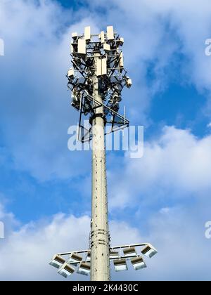 Telekommunikationsturm mit Antennen gegen den blau bewölkten Himmel Stockfoto