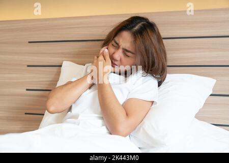 Teen Frau drückt ihre gequetscht Wange mit einem schmerzhaften Ausdruck, als ob sie eine schreckliche Zahnschmerzen. Stockfoto