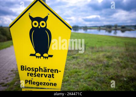 PRODUKTION - 27. September 2022, Mecklenburg-Vorpommern, Dömitz: In der Nähe der Elbbrücke steht ein Schild, das auf das geschützte Biosphärenreservat an der Elbe hinweist. Eine Biosphärenwoche feiert das 25.-jährige Jubiläum des UNESCO-Biosphärenreservats Elbe-Landschaft. Die Elblandschaft umfasst 278.660 Hektar. Am 30. September 2022 feiern die fünf Anrainerstaaten das Jubiläum. Foto: Jens Büttner/dpa Stockfoto