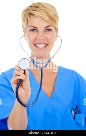 Bereit für eine Untersuchung. Eine junge lächelnde Ärztin hält ihr Stethoskop vor die Kamera. Stockfoto