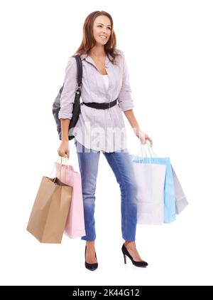 Stolz auf ihre Einkäufe. Lächelnde junge Frau, die einige Einkaufstaschen in der Hand hält - isoliert auf Weiß. Stockfoto