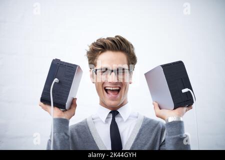 Begeistert von dem ganzen Speicherplatz. Ein junger Nerd hält zwei Festplatten hoch. Stockfoto