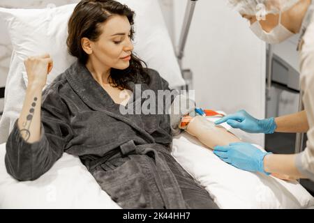 Frau mit Krankenschwester während des Blutwaschvorgangs im medizinischen Zentrum Stockfoto