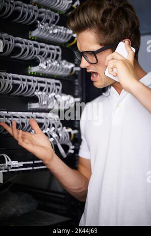 Kümmern Sie sich um Ihre Netzwerkanforderungen. Ein wütender Techniker, der am Telefon spricht. Stockfoto