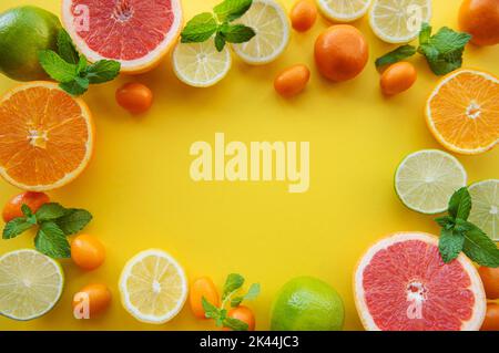 Rahmen aus reifen Früchten auf gelbem Hintergrund Stockfoto