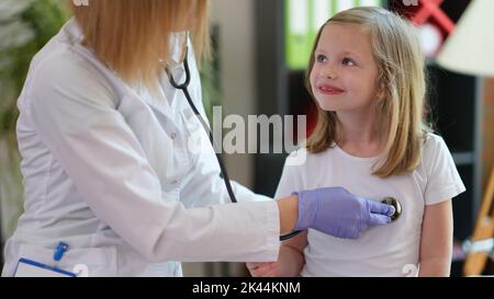 Kinderarzt hört auf den Klang der Lungen und des Herzens des kleinen Mädchens Stockfoto