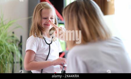 Kinder besuchen Arzt Mädchen mit Stethoskop kommuniziert mit Kinderarzt Stockfoto