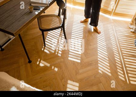 Frau geht zu Hause auf Holzparkett Stockfoto