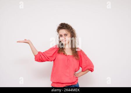 Lächelnde junge, schöne Geschäftsfrau, die etwas zeigt Stockfoto