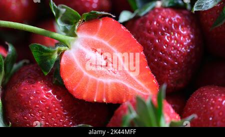 Die Hälfte der frischen Erdbeere und der ganzen Beere aus der Nähe Stockfoto