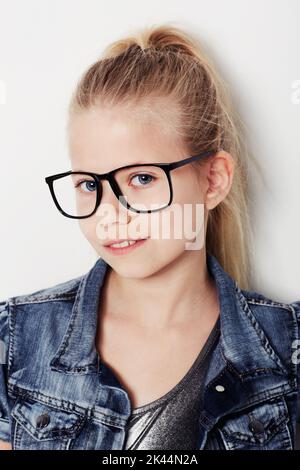 Sie zeigt ihre neuen Objektive. Porträt eines jungen Mädchens, das eine Brille trägt und im Studio posiert. Stockfoto