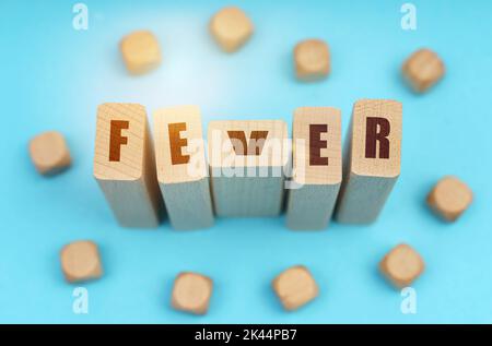 Medizinkonzept. Auf blauem Hintergrund Holzwürfel und Jenga mit der Aufschrift - Fever Stockfoto