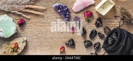 Set aus verschiedenen Kristallen und Runensteinen auf Holzhintergrund mit Kopierraum. Amethyst-Cluster, Fluorit, Calcit, Rosenquarz und andere Heilungsrufe Stockfoto