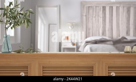 Tischplatte aus Holz, Schrank, Platte oder Regal mit Fensterläden aus nächster Nähe. Olivenzweig in Vase und Kerzen. Verschwommener Hintergrund mit skandinavischem Schlafzimmer mit Stockfoto