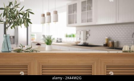 Tischplatte aus Holz, Schrank, Platte oder Regal mit Fensterläden aus nächster Nähe. Olivenzweig in Vase und Kerzen. Unscharfer Hintergrund mit weißer skandinavischer Küche Stockfoto