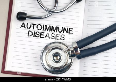 Medizinkonzept. Auf dem Tisch steht ein Stethoskop, ein Stift und ein Notizbuch, in dem es steht - Autoimmunerkrankungen Stockfoto