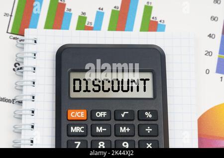Business- und Economy-Konzept. Auf der Tabelle sind die Diagramme, das Notizbuch und der Rechner mit der Aufschrift - RABATT Stockfoto