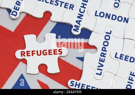 Nationales Konzept. Auf der Flagge Großbritanniens gibt es Rätsel mit den Namen der Städte und ein separates Puzzle mit der Aufschrift - Flüchtlinge Stockfoto