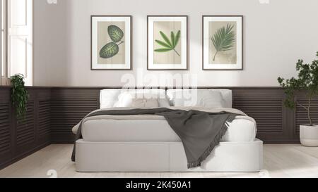 Modernes Schlafzimmer in Weiß- und Dunkeltönen. Bett, hölzerne Wandpaneele mit Bildern, Topfpflanzen und Parkett. Landhaus Konzept Idee, Innenarchitektur, Stockfoto