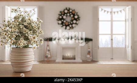 Hölzerne Tischplatte oder Regal mit Keramik Vase mit Gänseblümchen, Wildblumen, über Weihnachten Wohnzimmer mit Kamin, Fenster auf Winterlandschaft, Minima Stockfoto