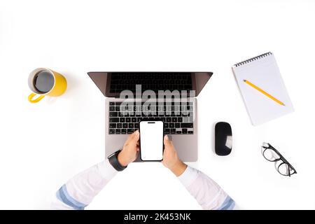 Frau, die am Laptop arbeitet, Foto von oben, auf dem sie am Laptop arbeitet. Mit dem Smartphone zum Nachmachen. Weißer leerer Bildschirm. Büroschreibtisch, Maus. Stockfoto