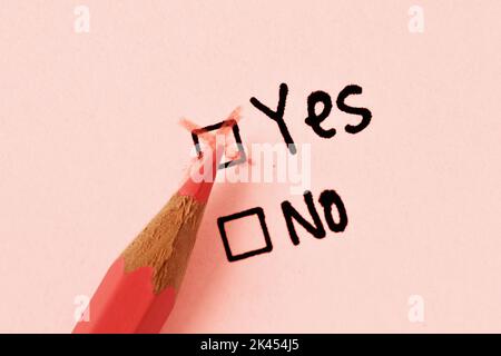 Nahaufnahme eines pinkfarbenen Bleistifts und Kontrollkästchen „Ja“ mit aktiviertem Kontrollkästchen „Ja“ - Frauenbegriff und „Ja“ oder „Nein“ Stockfoto