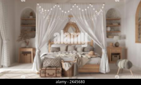 Verschwommener Hintergrund, unkonventionelle Schlafzimmer mit Himmelbett. Parkett und ethnische Teppiche. Rattan- und Holzmöbel. Innenarchitektur im Boho-Stil Stockfoto