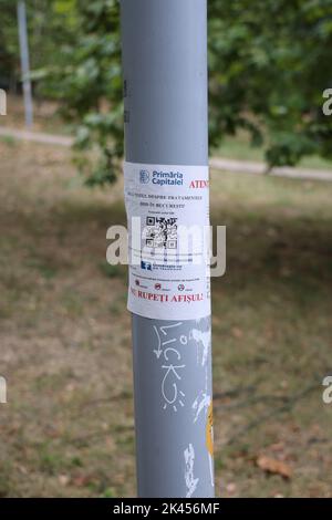 Ein offizielles Plakat (Papiermitteilung) von Stadtbehörden, das vor Rattengift warnt, das verwendet wurde; an einem Pol in einem Park in Bukarest, Rumänien Stockfoto