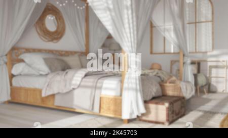 Verschwommener Hintergrund, Nahaufnahme des Schlafzimmers mit Himmelbett. Decken, Bettdecken und Kissen. Böhmische Rattan- und Holzmöbel. Innenarchitektur im Boho-Stil Stockfoto