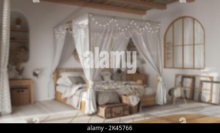 Verschwommener Hintergrund, elegantes Schlafzimmer mit Himmelbett. Parkett, Naturtapete und Rohrdecke. Böhmische Rattan- und gebleichte Holzmöbel. Boho Stockfoto