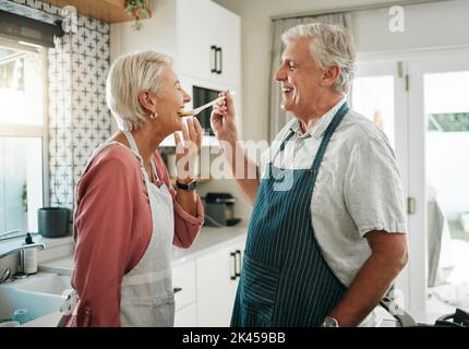 Seniorenpaar, Geschmack und Essen in der Küche gesund kochen, Ernährung und romantisches Abendessen zusammen zu Hause. Glücklicher und älterer Mann und Frau im Ruhestand Stockfoto