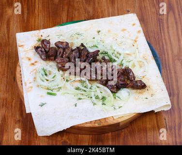 Kebab aus Hühnerherzen auf Pita-Brot mit Kräutern und Zwiebeln schälen Stockfoto