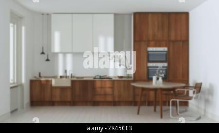 Verschwommener Hintergrund, japanische trendige Holzküche und Esszimmer. Holzschränke, Tisch und Marmorplatte. Minimalistisches Innendesign Stockfoto
