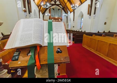 Eine bibel sitzt auf einer Kanzel, die bei Römer 13, 14 und 15 geöffnet ist. Stockfoto