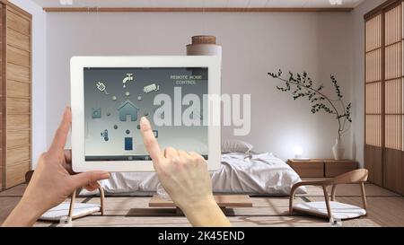 Intelligentes Fernbedienungssystem für Zuhause auf einem digitalen Tablet. Gerät mit App-Symbolen. Minimalistisches, modernes japandiisches Schlafzimmer im Hintergrund, Architektur-Interio Stockfoto