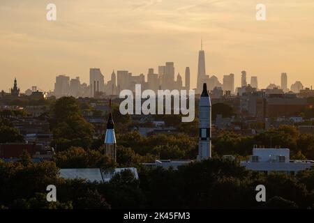 Fernansicht der Skyline von Manhattan in der Abenddämmerung, Vordergrundraketen im Space Park in Corona Park, Flushing Meadows, New York, USA, Stockfoto