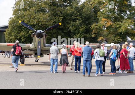 Menschen, die ein altes spitfire-Flugzeug aus dem Jahr WW2 betrachten, das auf einer Flugschau im Imperial war Museum, Duxford UK ausgestellt ist Stockfoto