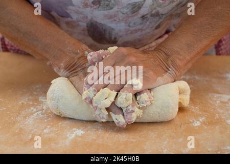 Weibliche Hände kneten den Teig Stockfoto