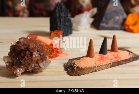 Aragonitkristall mit Weihrauch und Steinpyramide auf Meditationstisch Stockfoto