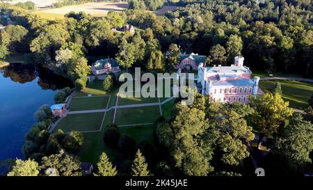 Luftaufnahme des Birinu-Palastes. Lettische Burg am See mit hübscher Gartenanlage, Drohnenaufnahme. Birini Manor, Region Vidzeme, Lettland. Sonniger Herbsttag Stockfoto