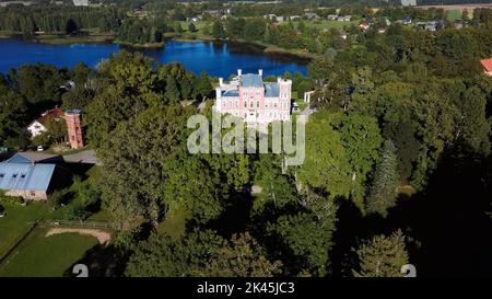 Luftaufnahme des Birinu-Palastes. Lettische Burg am See mit hübscher Gartenanlage, Drohnenaufnahme. Birini Manor, Region Vidzeme, Lettland. Sonniger Herbsttag Stockfoto