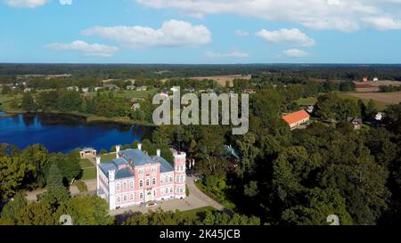 Luftaufnahme des Birinu-Palastes. Lettische Burg am See mit hübscher Gartenanlage, Drohnenaufnahme. Birini Manor, Region Vidzeme, Lettland. Sonniger Herbsttag Stockfoto