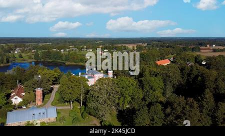 Luftaufnahme des Birinu-Palastes. Lettische Burg am See mit hübscher Gartenanlage, Drohnenaufnahme. Birini Manor, Region Vidzeme, Lettland. Sonniger Herbsttag Stockfoto