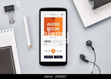 Overhead-Ansicht des Smartphone-Bildschirms mit geöffneter Hörbuch-App auf dem Schreibtisch Stockfoto