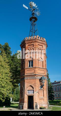 Old Red Brick Water Tower Windmühle Wetterfahne. Blick auf die Dawn of an Old and Abandoned Weather Vane Stockfoto