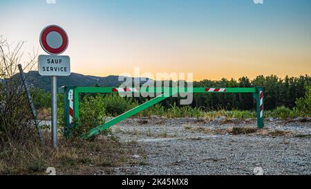 Eingangstor zur Fabrik mit einem No-Entry-Schild bei Sonnenuntergang und Blick auf die Berge Stockfoto